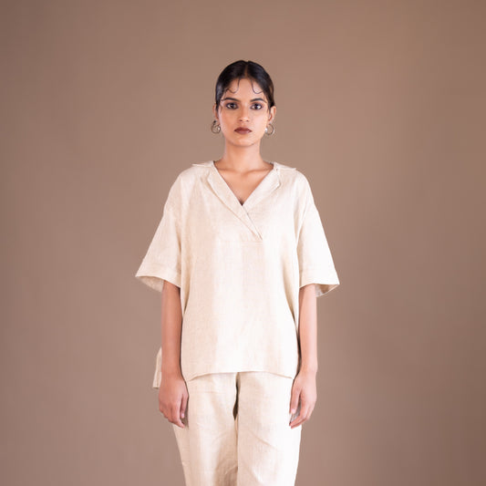 Woman wearing a beige outfit against a brown background