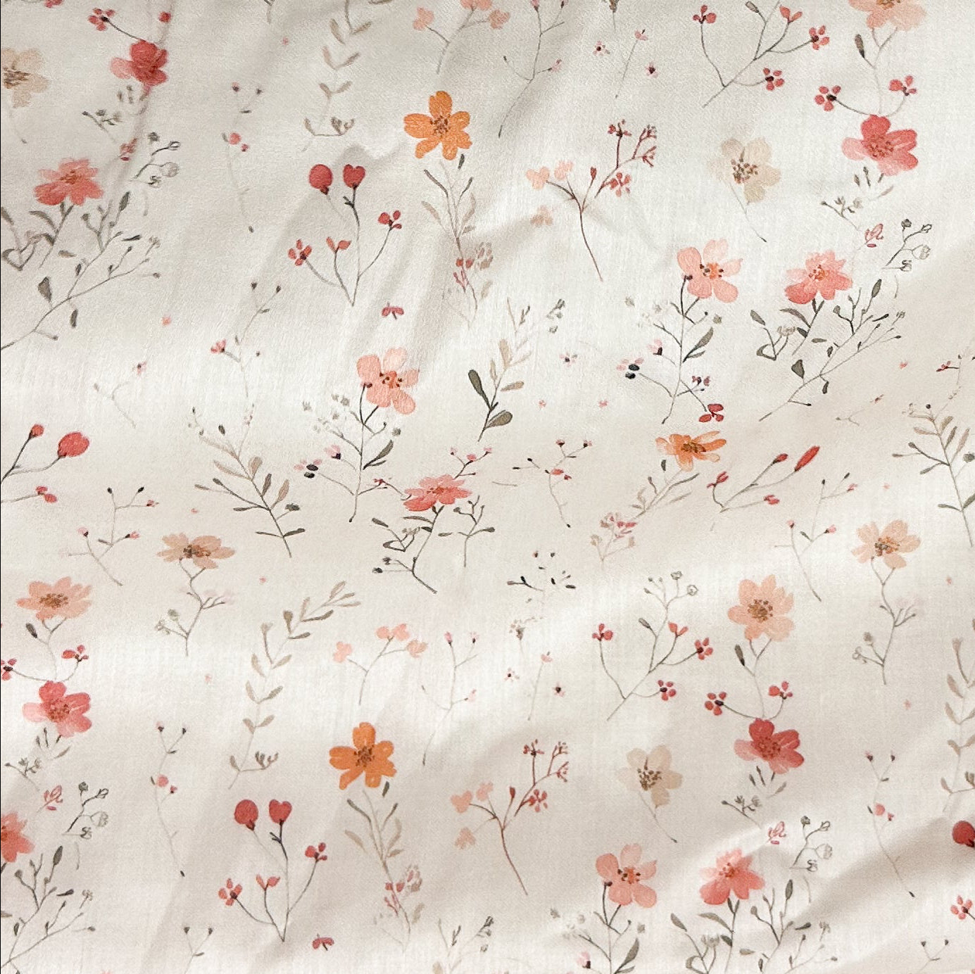 Floral patterned fabric with small flowers and leaves on a light background