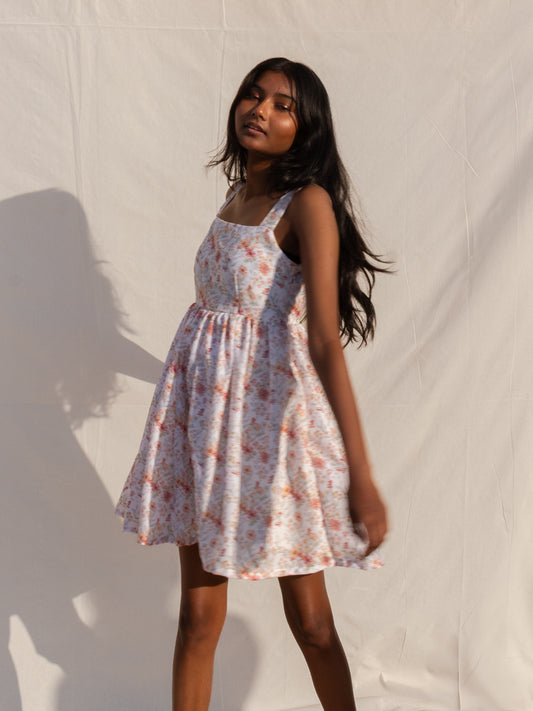 Woman wearing a floral dress against a plain background