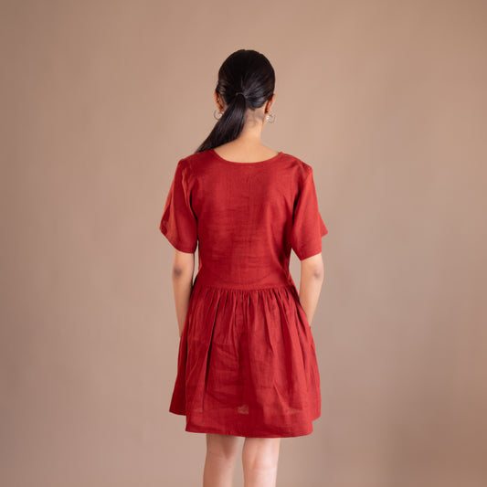 Woman wearing a red dress against a beige background
