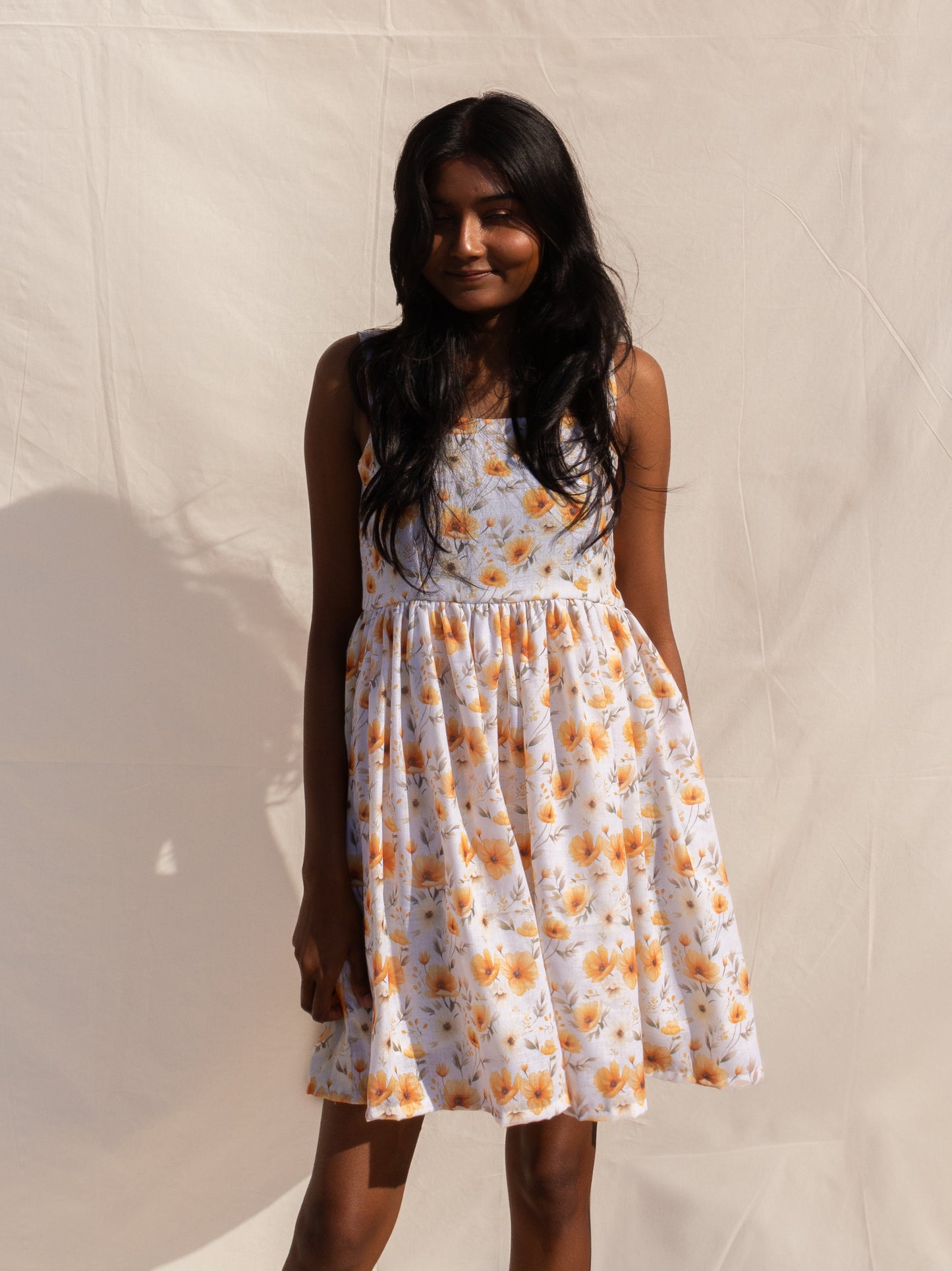 Woman wearing a floral dress against a plain background