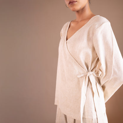Beige outfit with a tie detail on a plain background