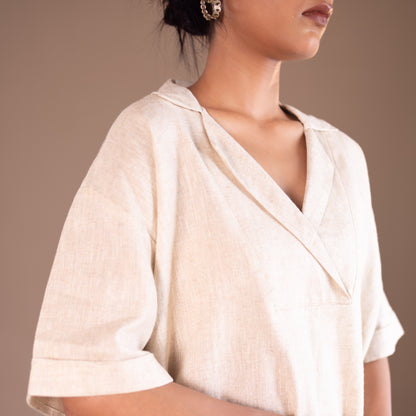 Woman wearing a light-colored blouse against a neutral background