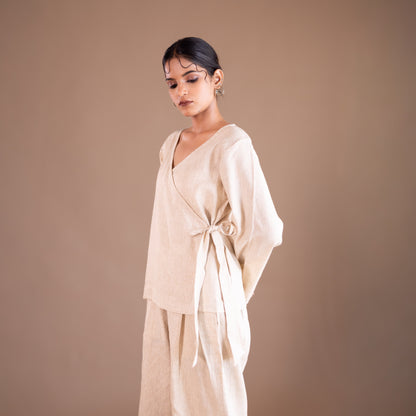 Woman wearing a beige outfit against a brown background