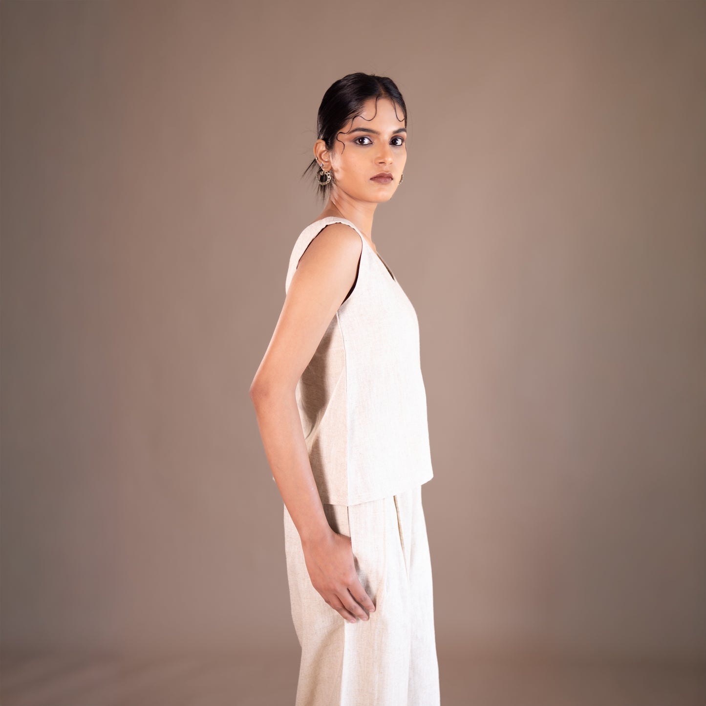 Woman wearing a white dress against a brown background