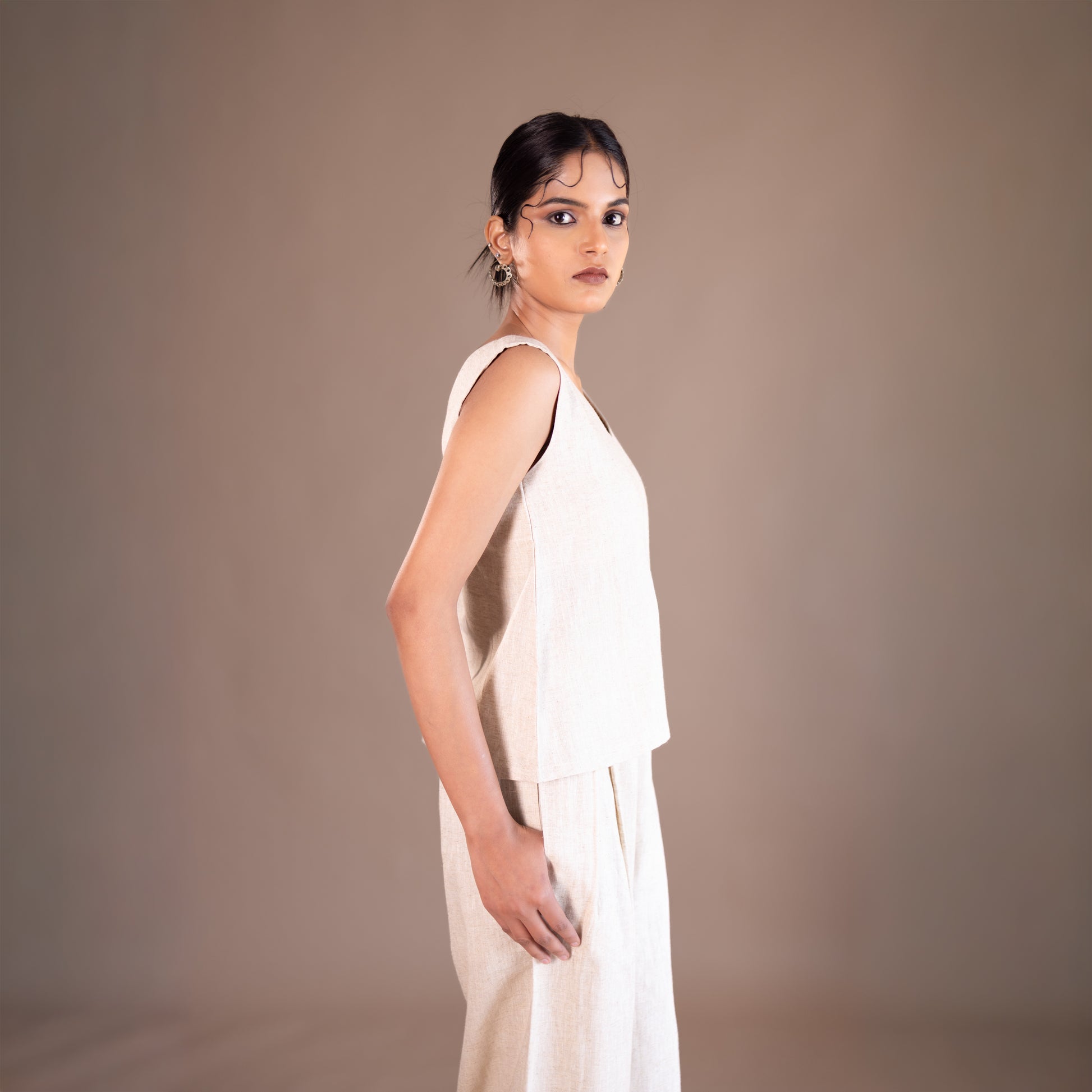 Woman wearing a white dress against a brown background