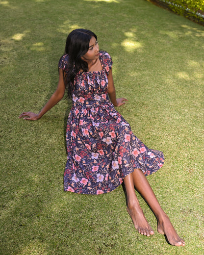 Woman in a floral dress sitting on grass