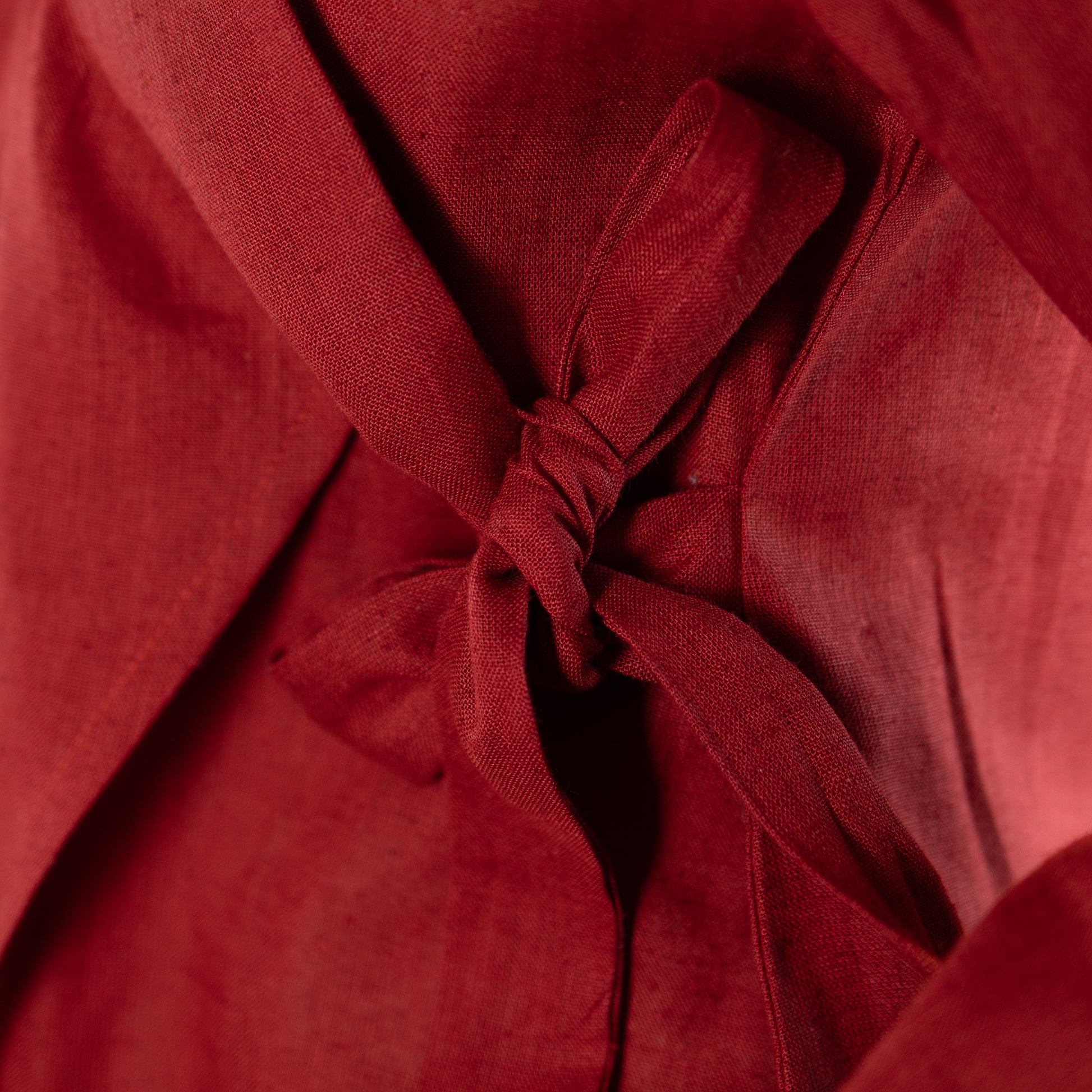 Close-up of a red fabric with a knot, possibly from a garment.