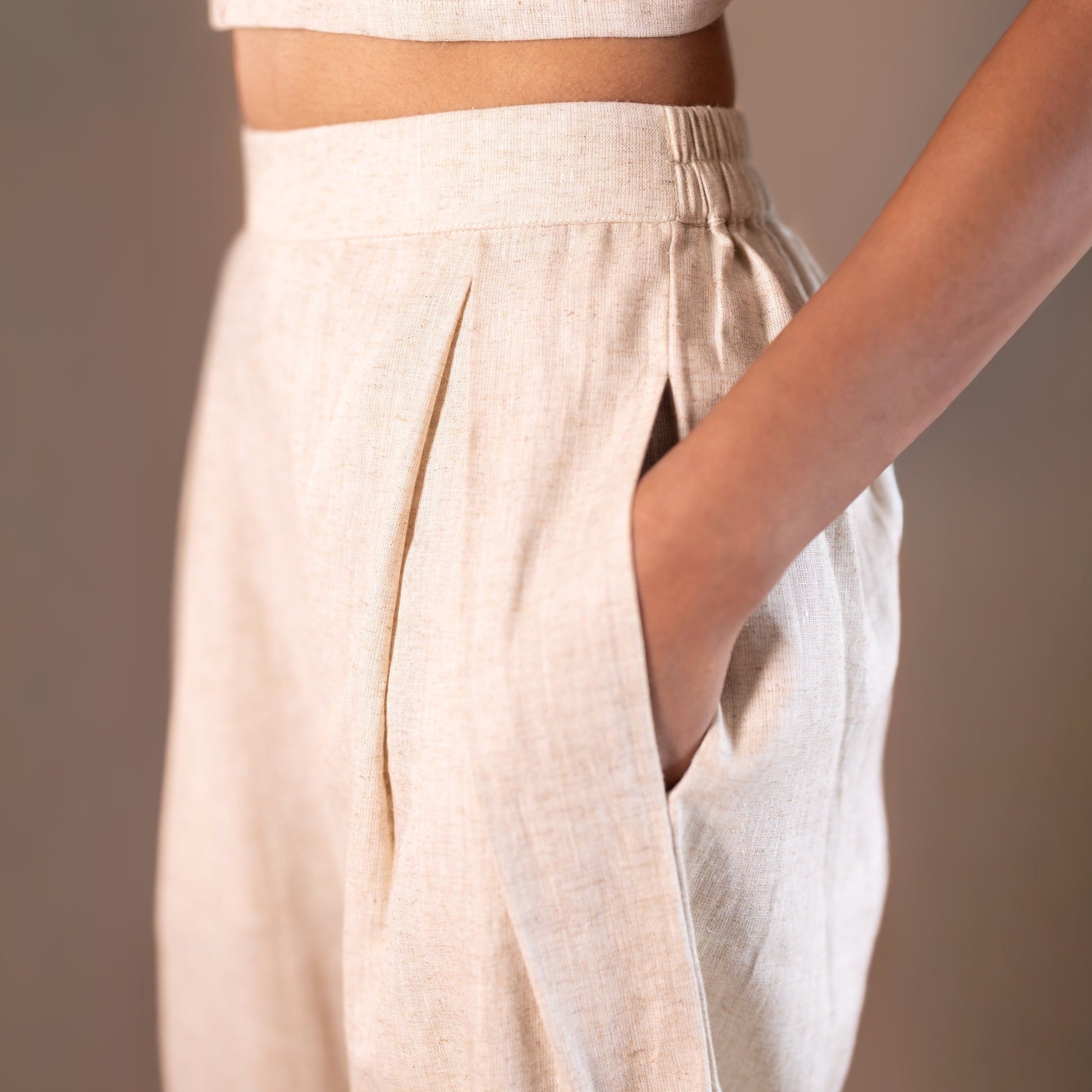 Elasticated Beige pants worn by a person on a plain background