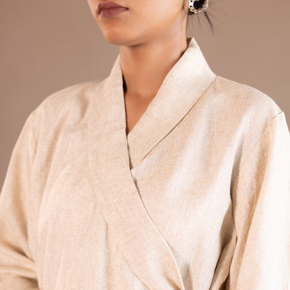 Close-up of a person wearing a beige robe against a neutral background
