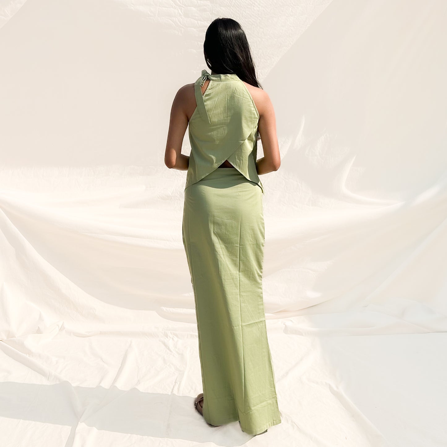 Woman wearing a green outfit against a white background