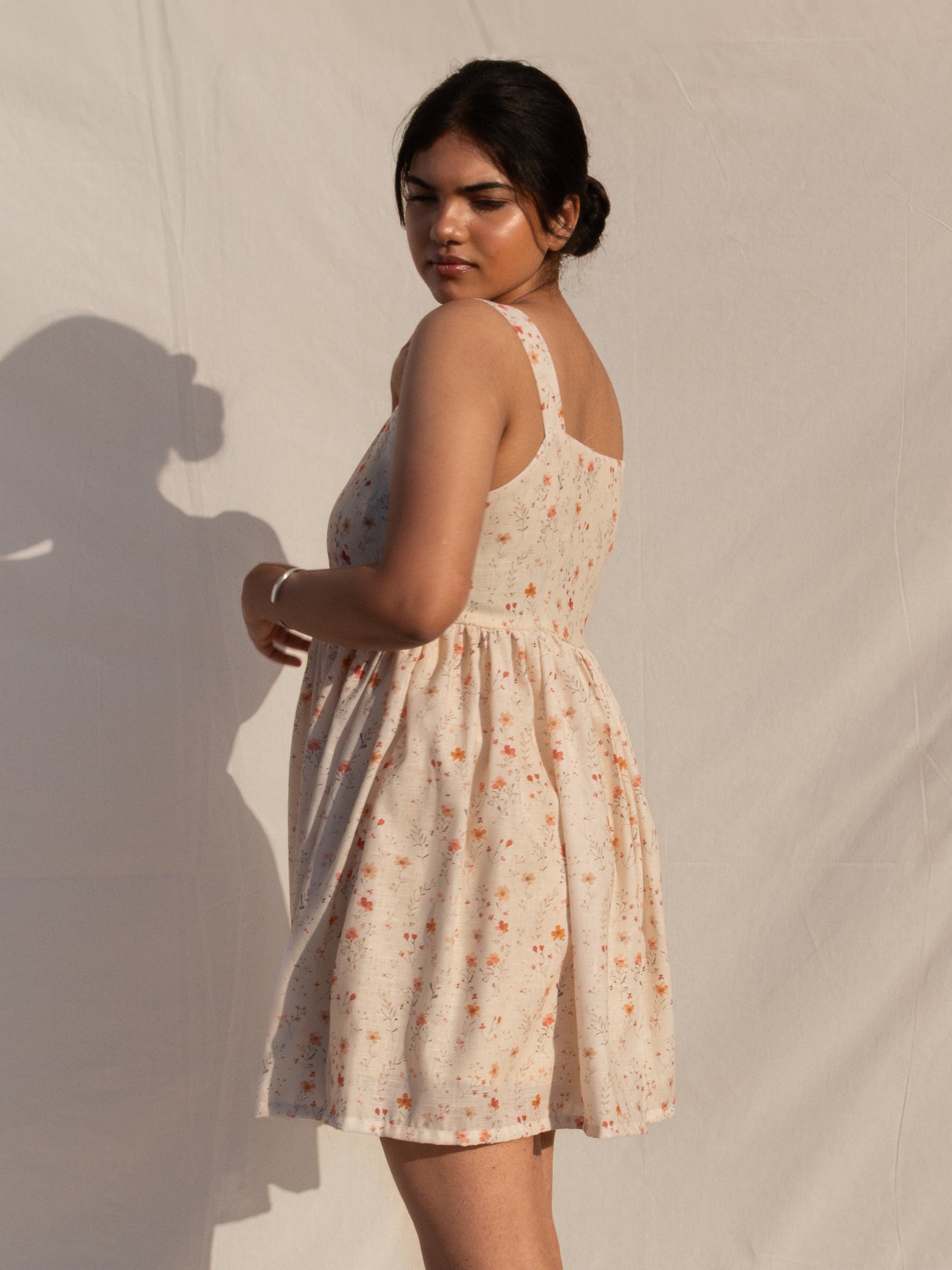 Woman wearing a floral dress against a plain background