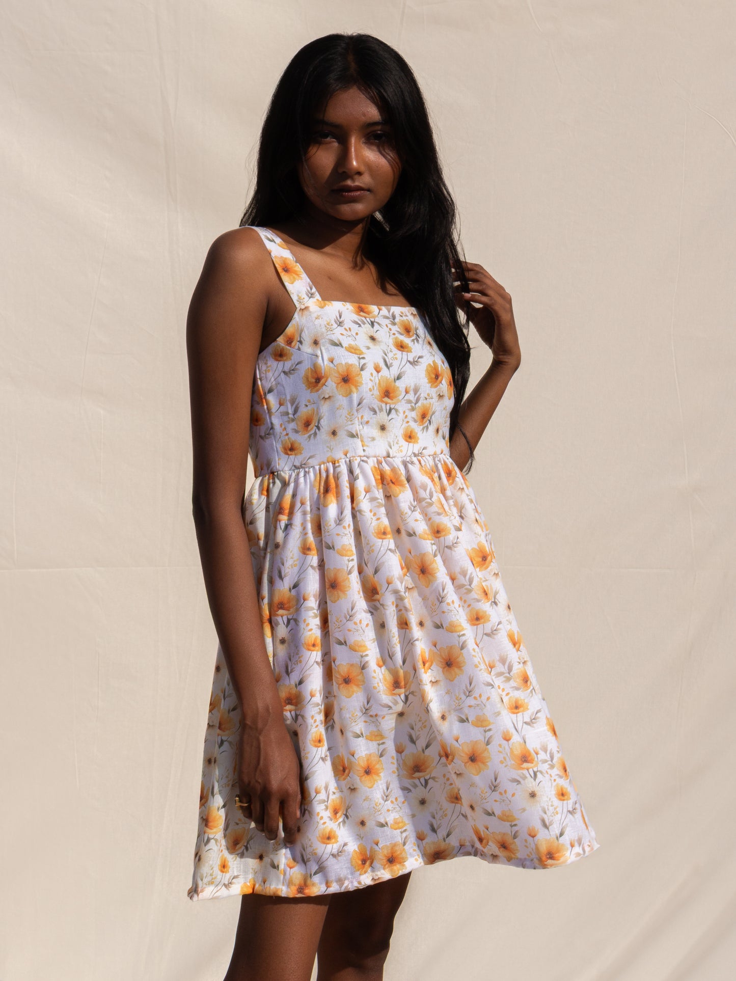 Woman wearing a floral dress against a plain background