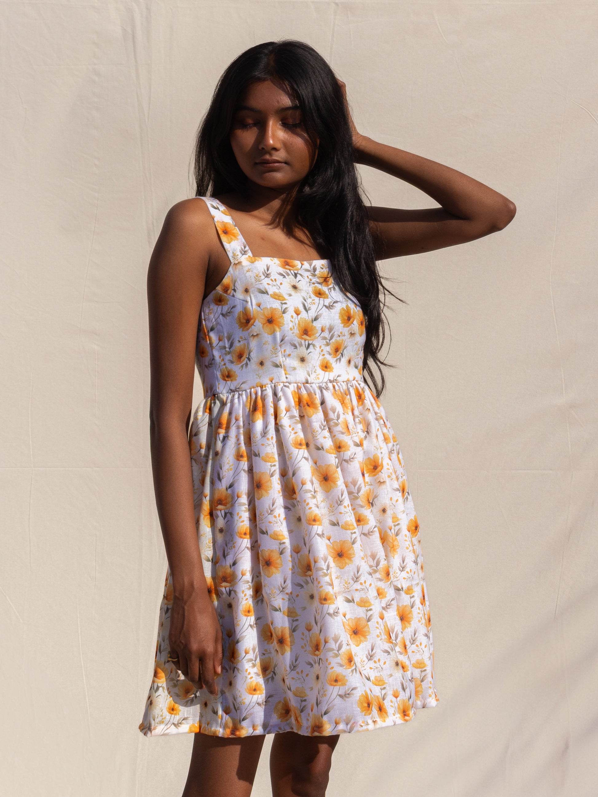 Woman wearing a floral dress against a plain background