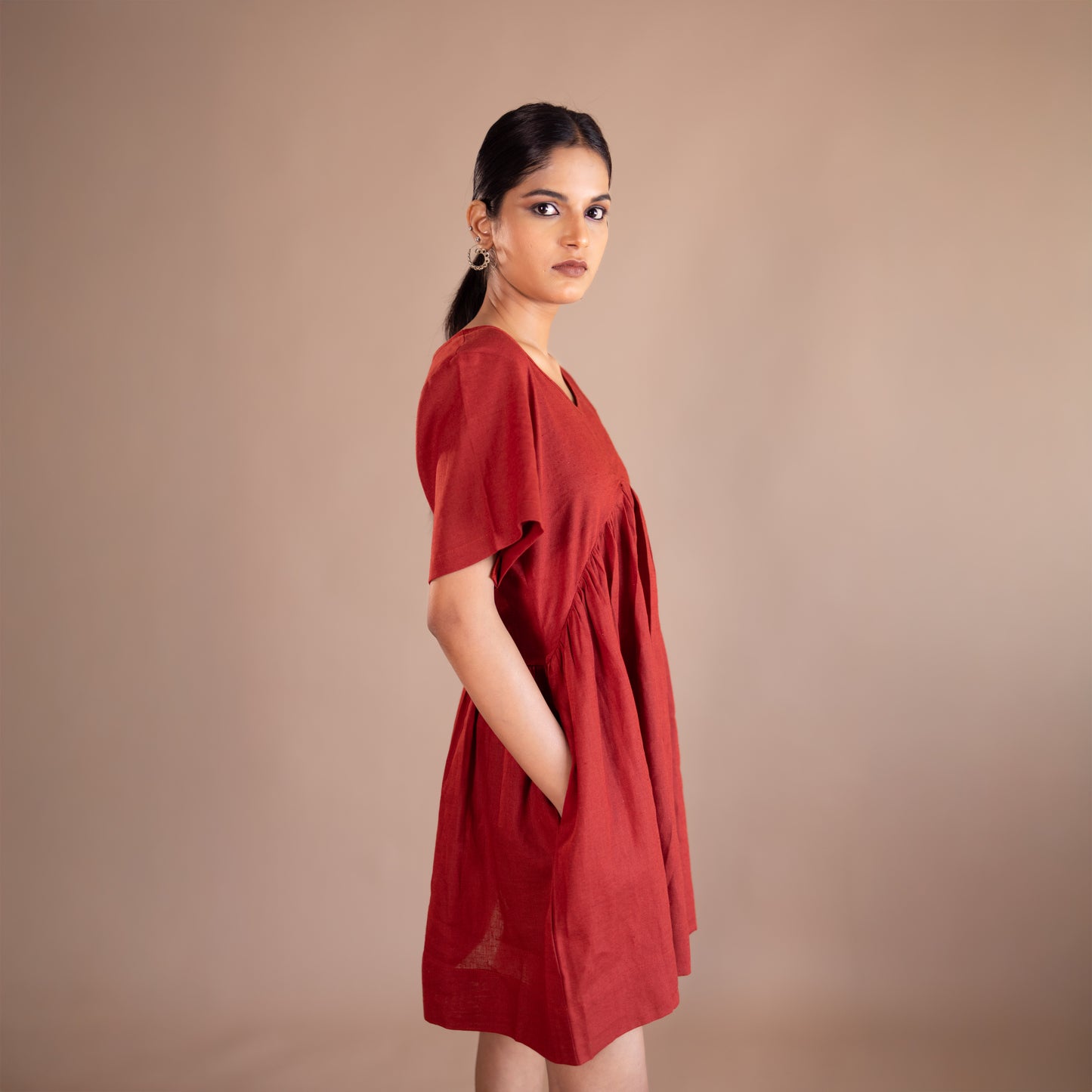 Woman wearing a red dress against a beige background