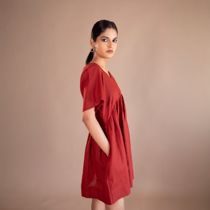 Woman wearing a red dress against a beige background