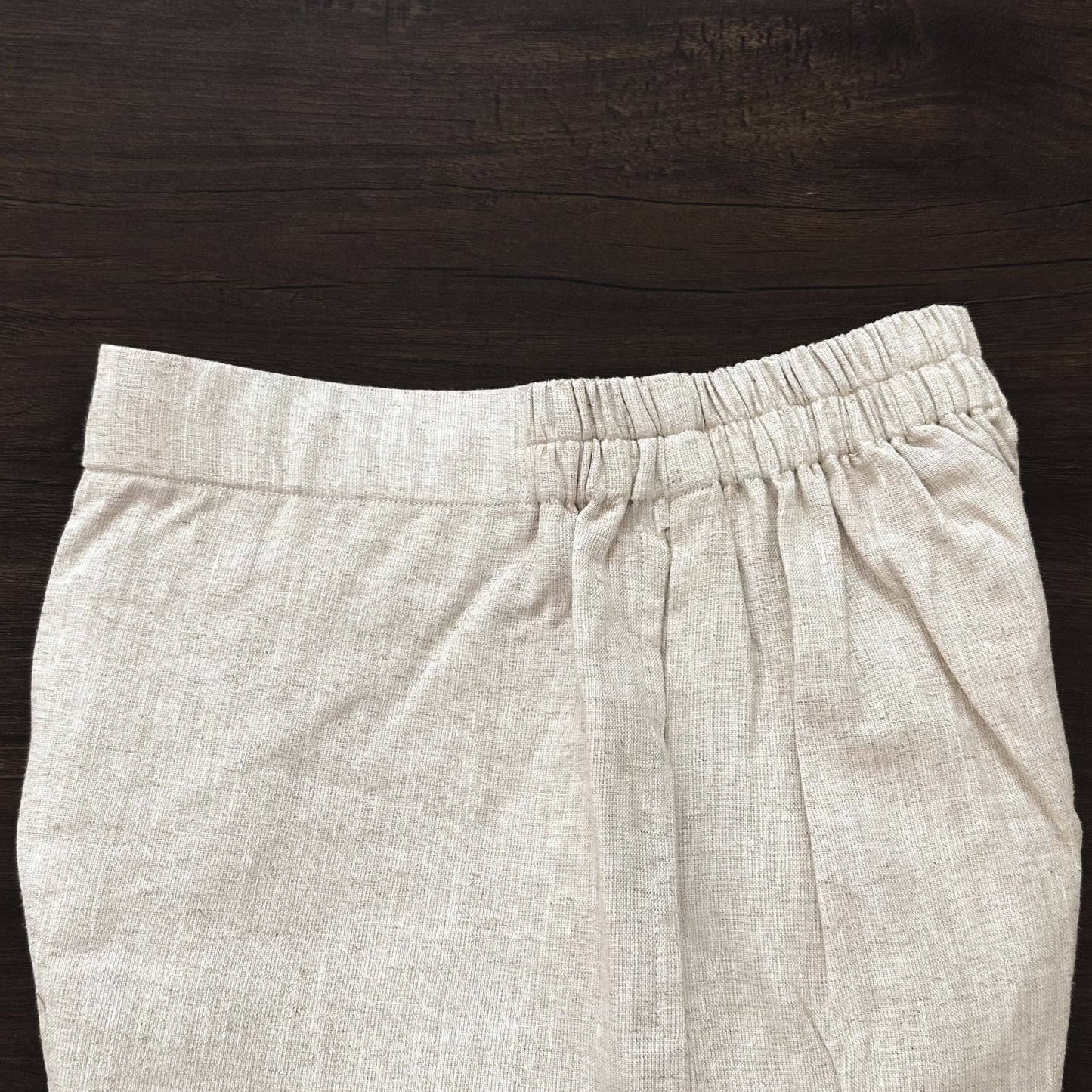 Beige pants on a dark wooden surface