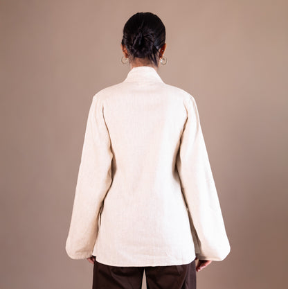 Person wearing a beige jacket on a brown background