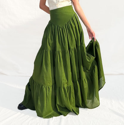 Woman wearing a white top and green skirt on a white background