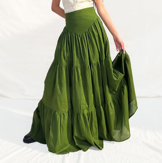 Woman wearing a white top and green skirt on a white background
