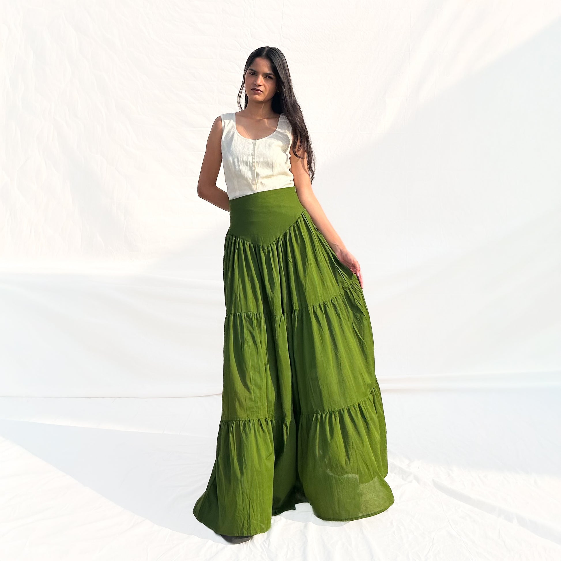 Woman wearing a white top and green skirt on a white background