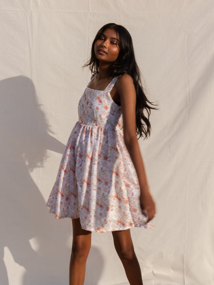 Woman wearing a floral dress against a plain background