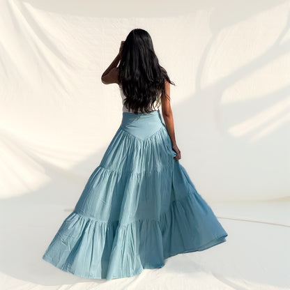 Woman wearing a blue tiered skirt against a white background