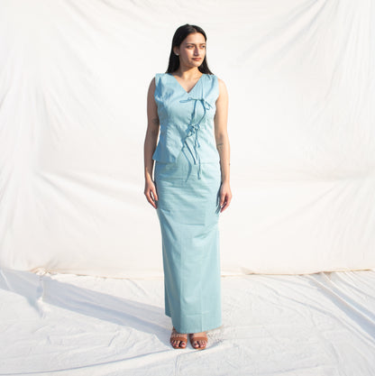 Woman wearing a light blue dress standing on a white background