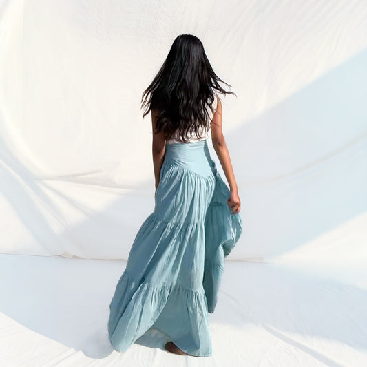 Woman in a light blue dress standing against a white background