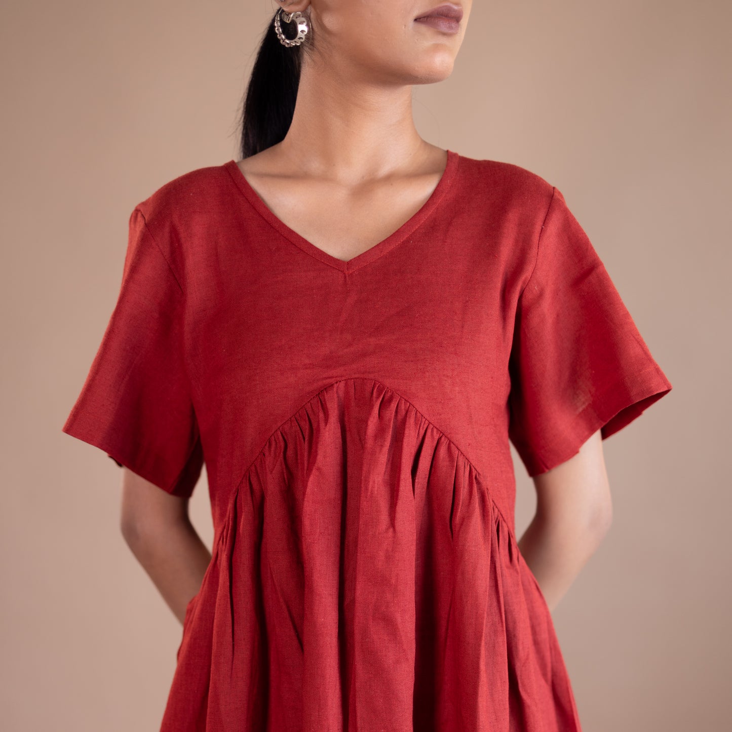 Red dress worn by a person on a beige background