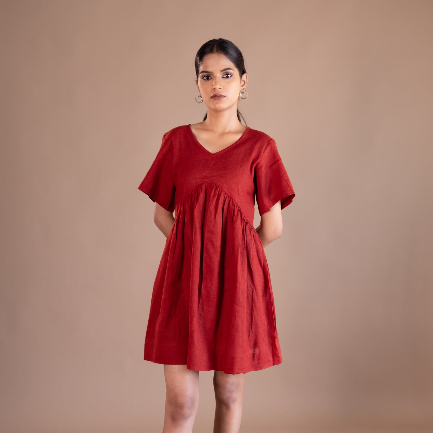 Woman wearing a red dress against a brown background