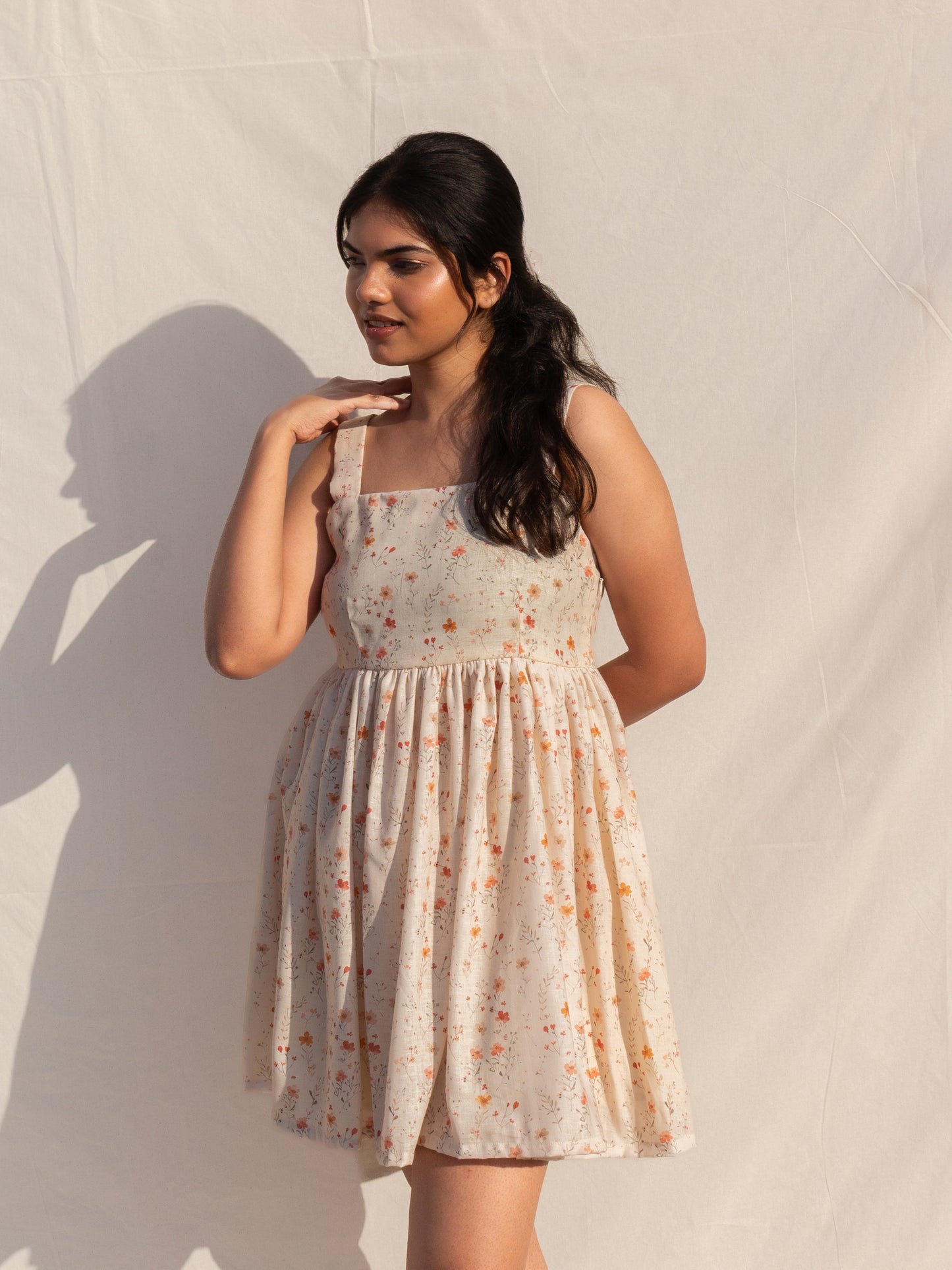 Woman wearing a floral dress against a plain background