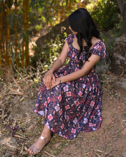Woman in a floral dress sitting in a forest
