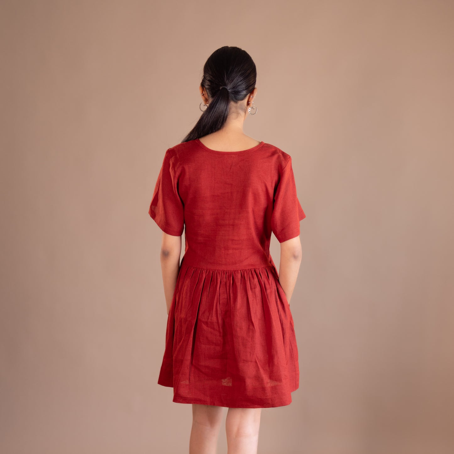 Woman wearing a red dress against a beige background