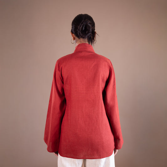 Person wearing a red top against a brown background