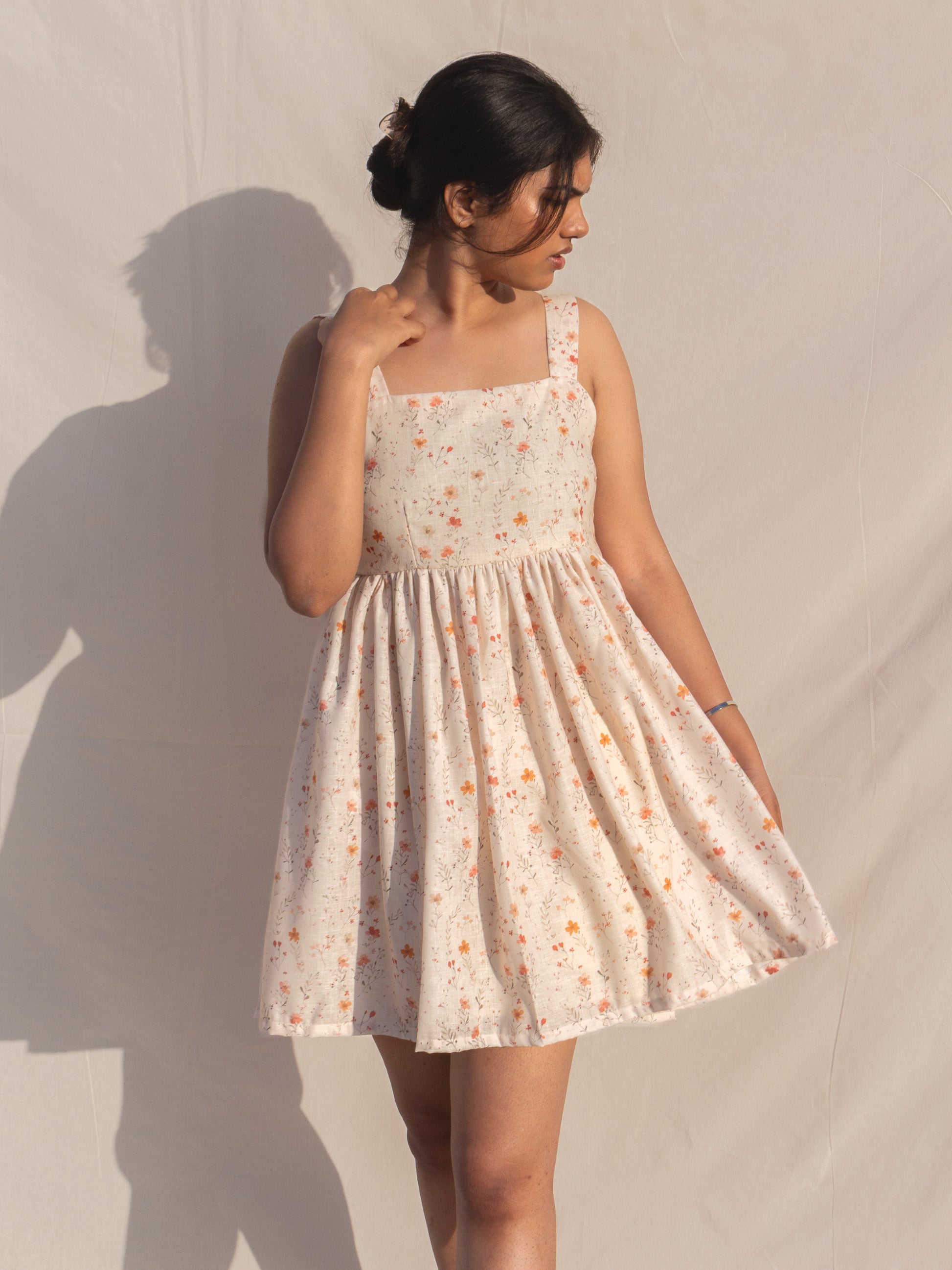 Woman wearing a floral dress against a plain background