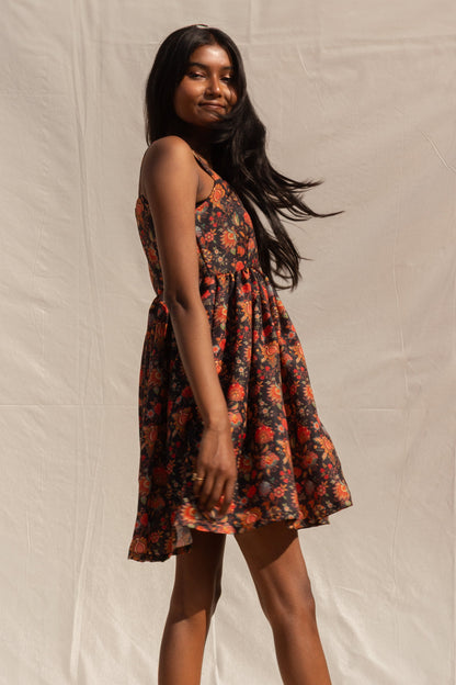 Woman wearing a floral dress against a plain background