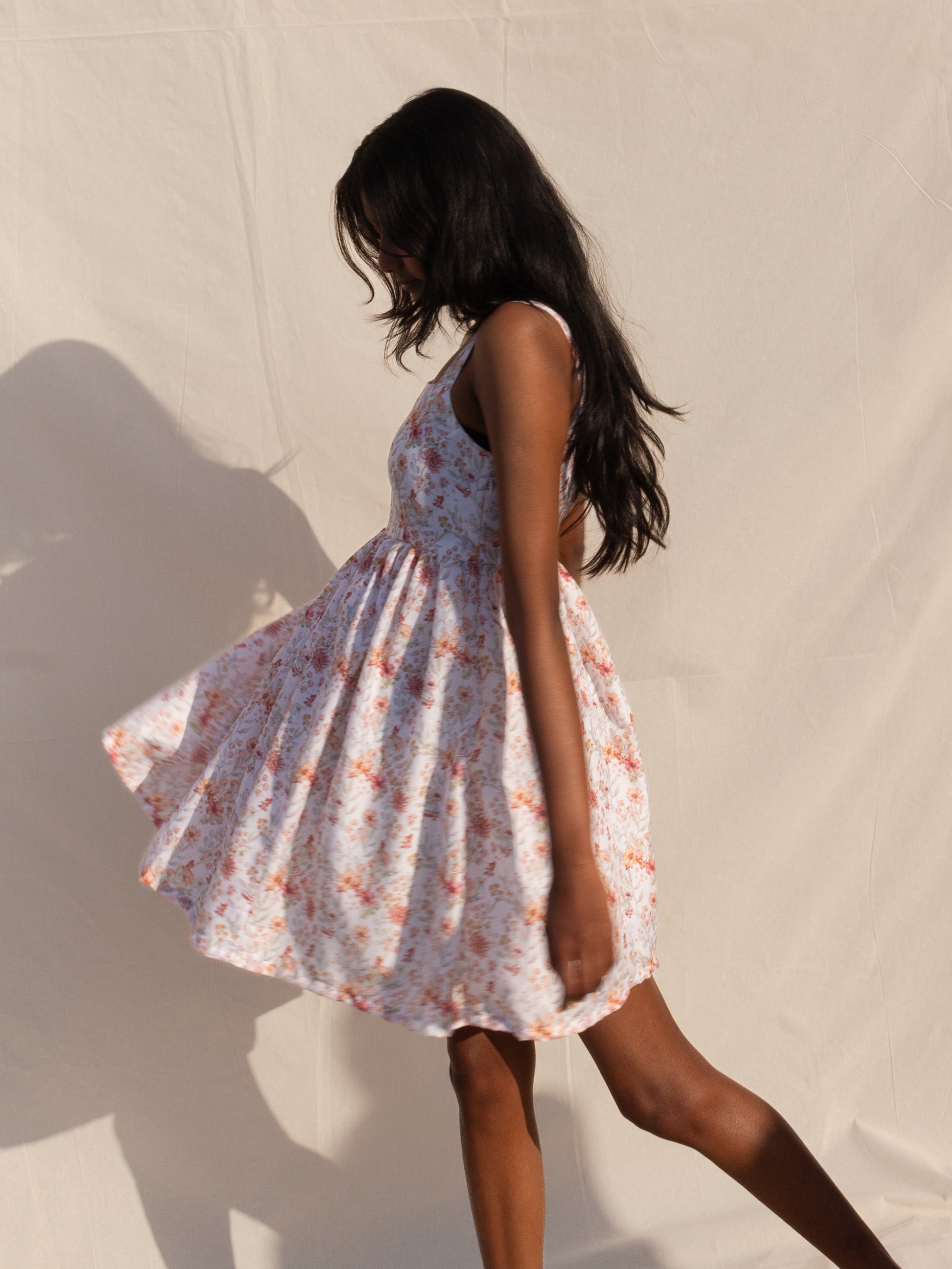 Woman wearing a floral dress against a neutral background