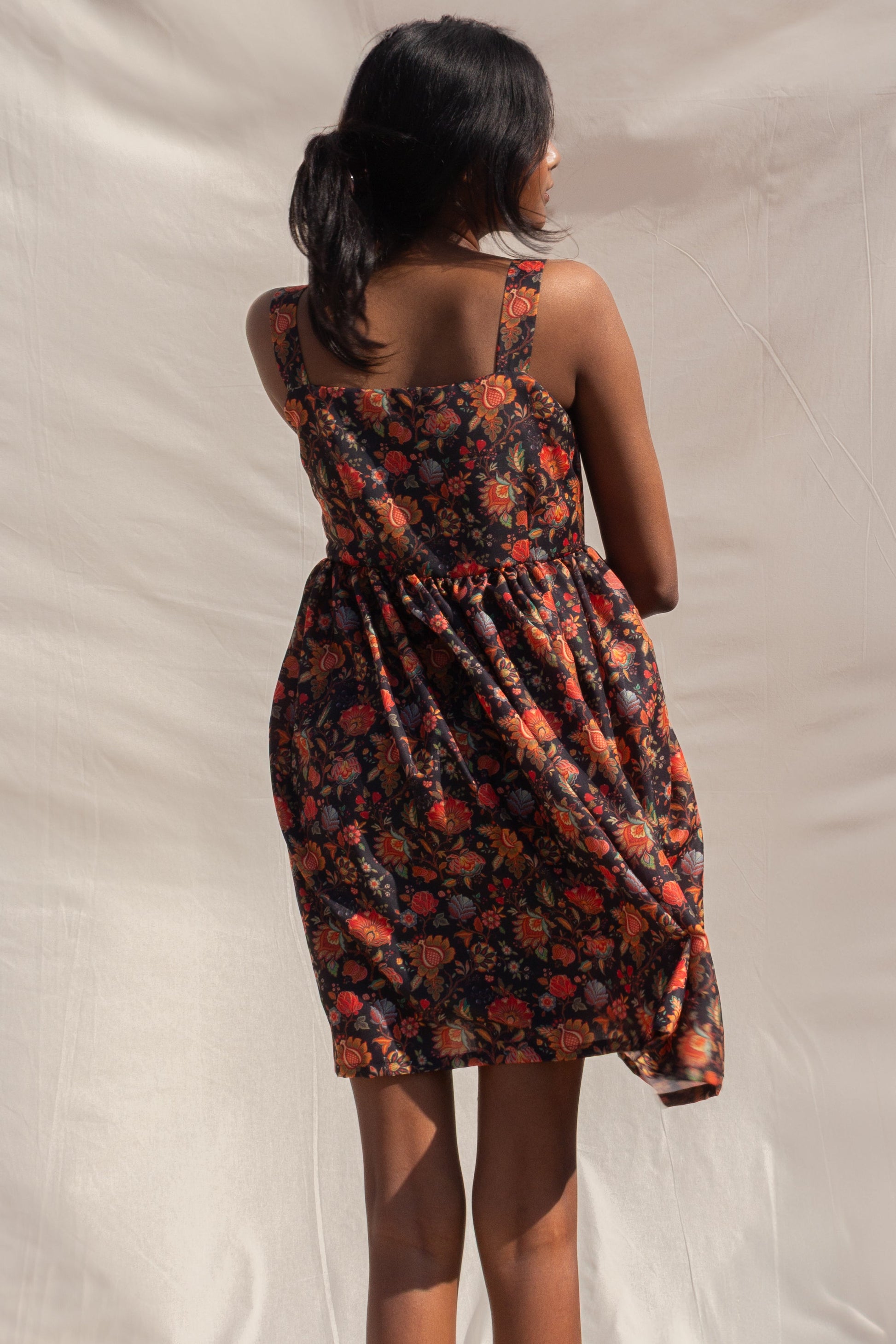 Woman wearing a floral dress with a neutral background