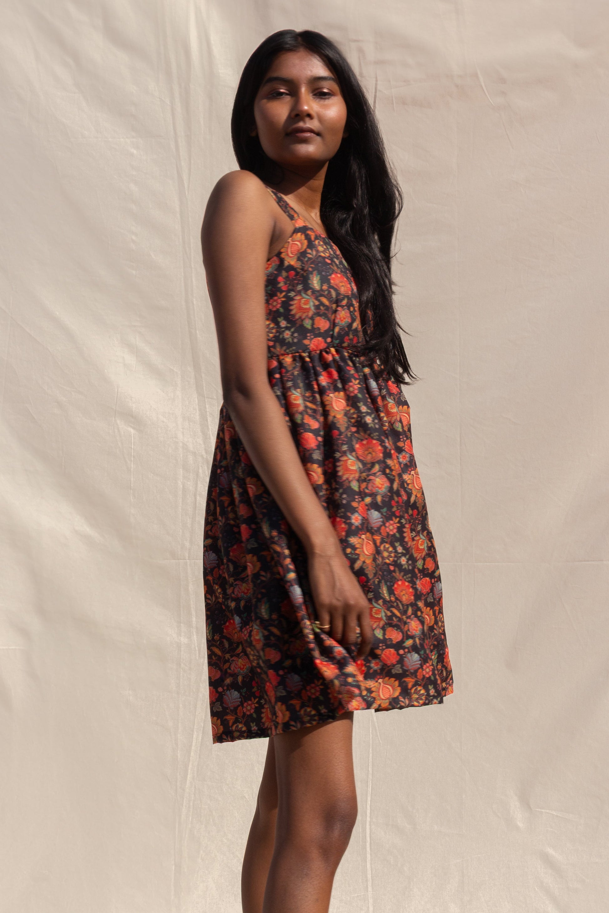 Woman wearing a floral dress against a plain background