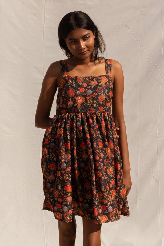 Woman wearing a floral dress against a plain background