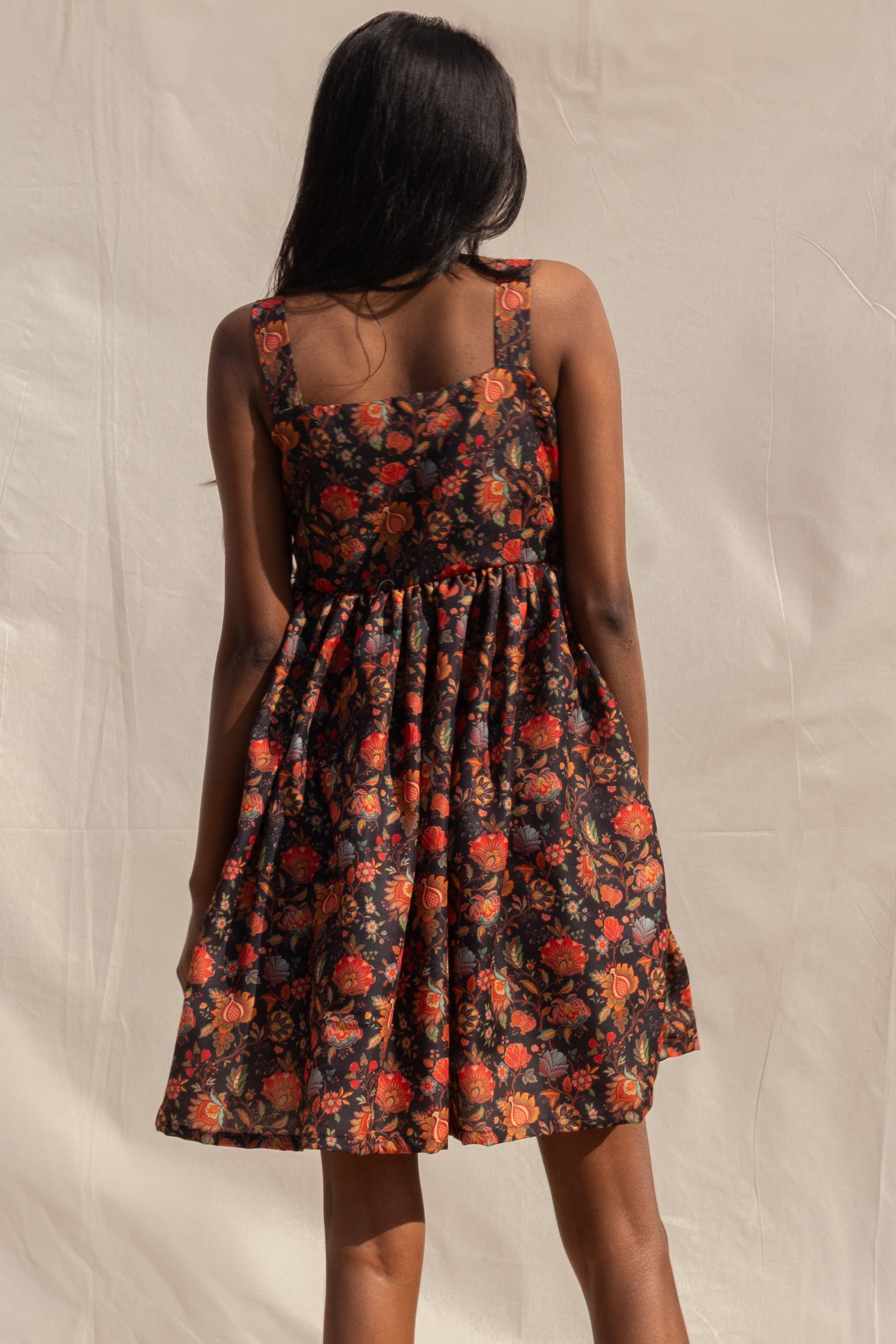 Woman wearing a floral dress with a neutral background