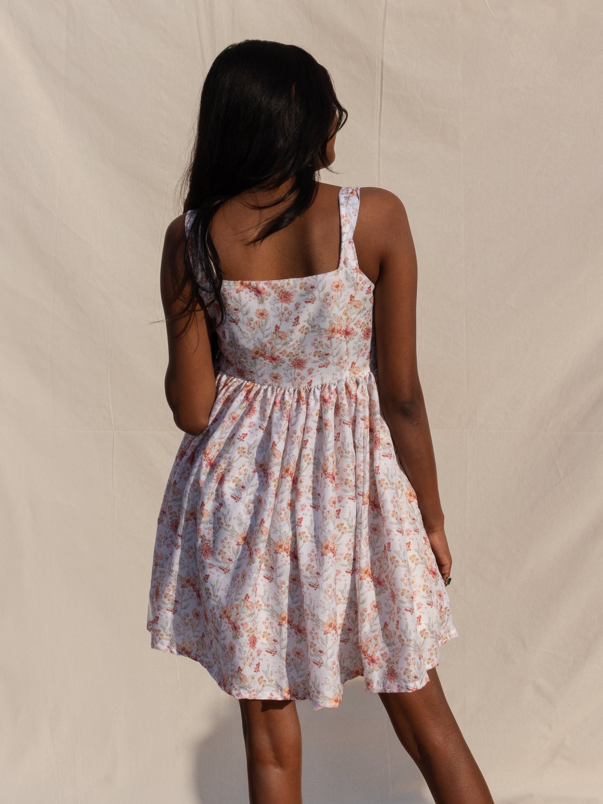 Woman wearing a floral dress against a plain background