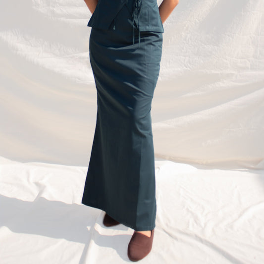 Woman wearing a sleeveless dark blue dress against a white background