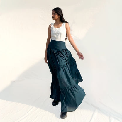 Woman wearing a white top and dark green skirt on a white background