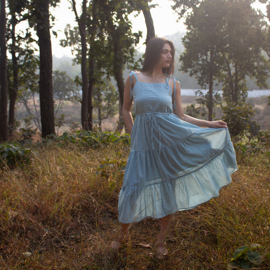 Woman in a blue dress standing in a forest