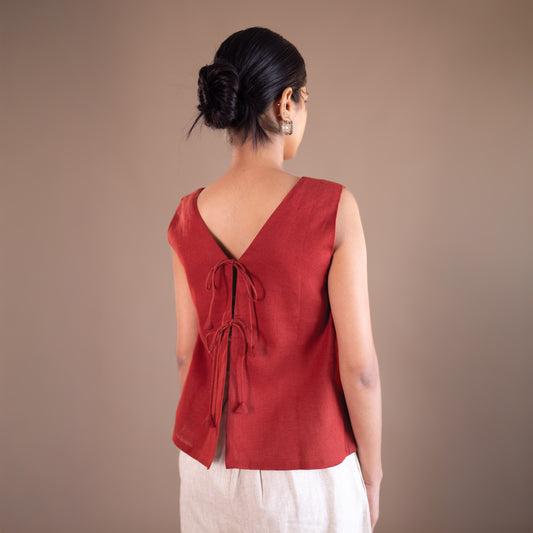 Woman wearing a red sleeveless top with a brown background