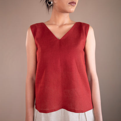 Red sleeveless top worn by a person on a beige background