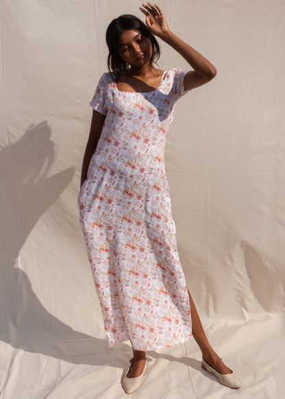 Woman wearing a floral dress against a neutral background